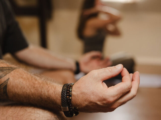 Close-up van een hand in meditatiehouding tijdens ademwerk