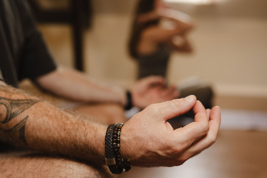 Close-up van een hand in meditatiehouding tijdens ademwerk