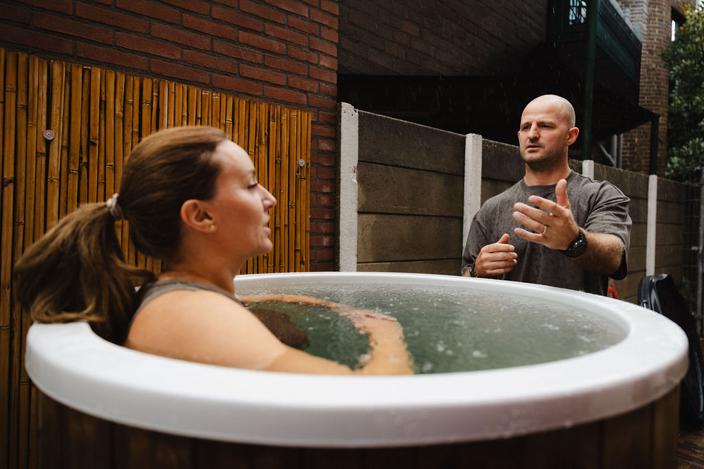 Deelnemer in het ijsbad met begeleiding tijdens de Breathwork & Icebath-workshop