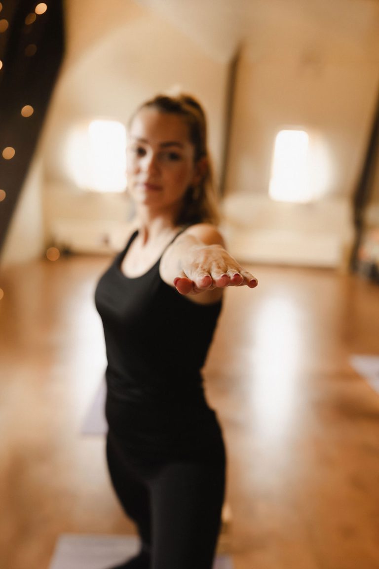 Yogadocent met uitgestrekte arm in De Shala