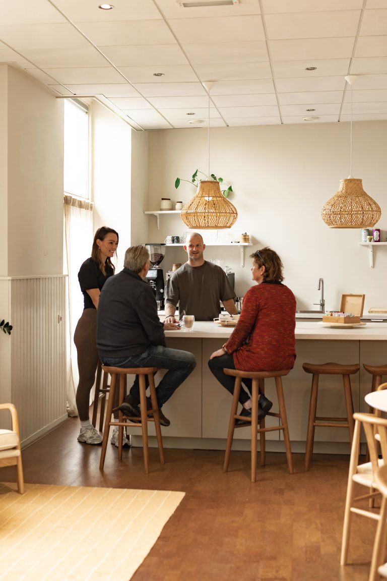 Oudere leden in gesprek aan de bar van de Members Lounge
