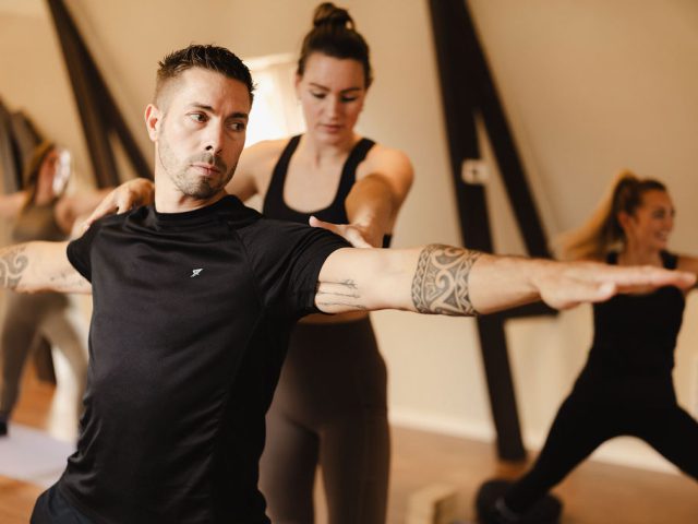 Docent begeleidt een groep tijdens yoga in De Shala